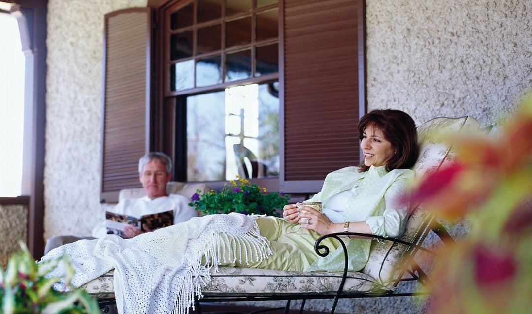 Guests relaxing on the porch of a private oasis--the Market Gardener's Cottage on Biltmore Estate