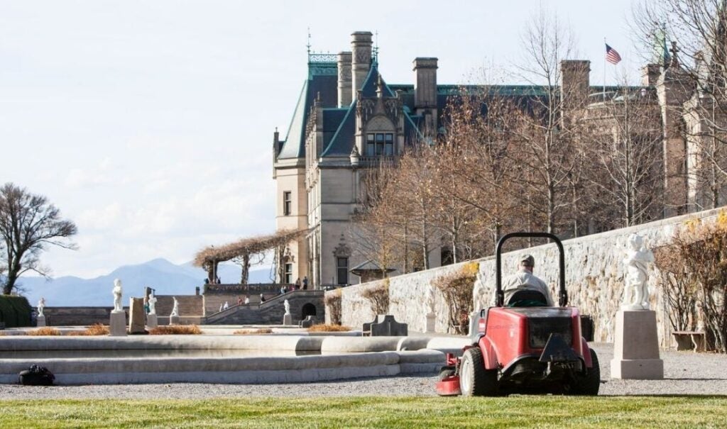 A member of Biltmore's turf maintenance team mows grass in the Italian Garden