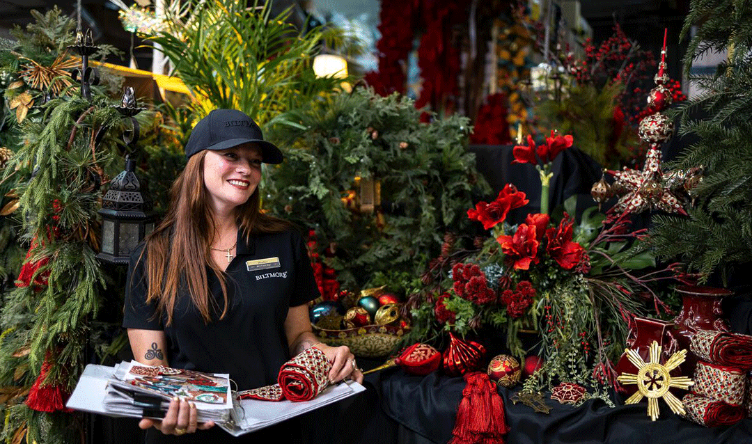 Woman holding a notebook and surrounded by Christmas decorations