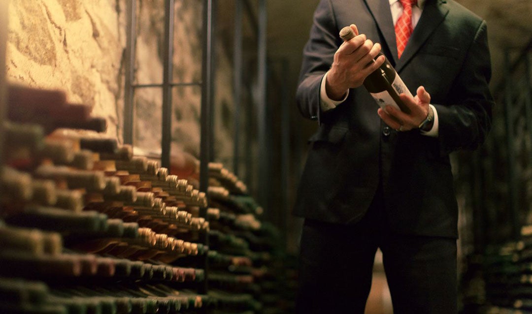 Man in a suit examining the library of Biltmore wines in the Winery