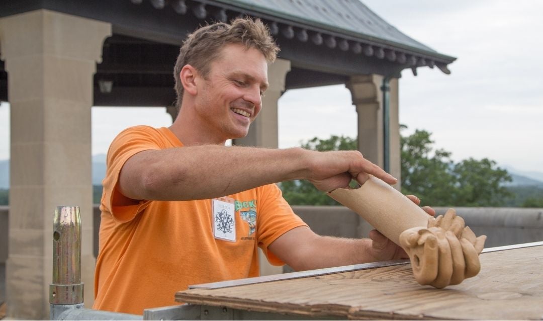 Irvine works with the statue's new ceramic arm.