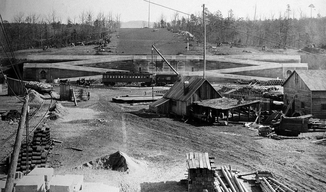 Archival photo of Biltmore House construction looking toward Vista with railroad and train in view.
