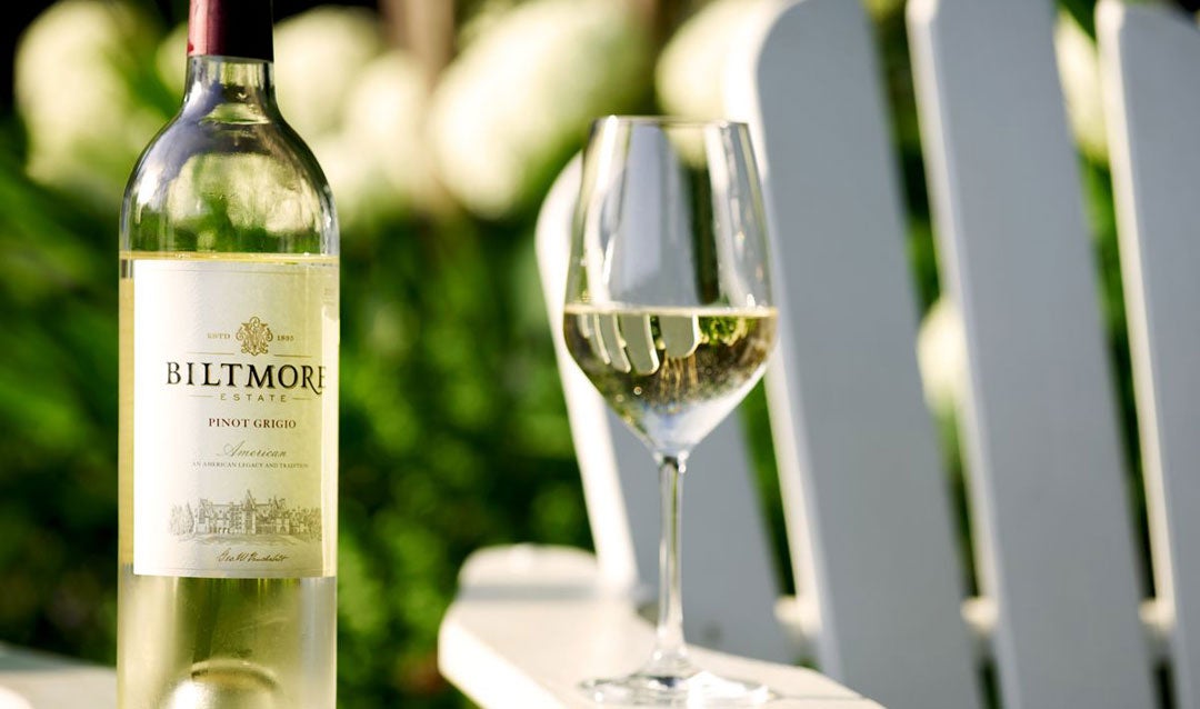 Bottle of Biltmore white wine with a white Adirondack-style chair.