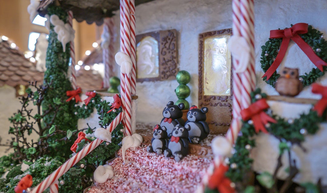 A family of bears on the steps of the gingerbread cottage