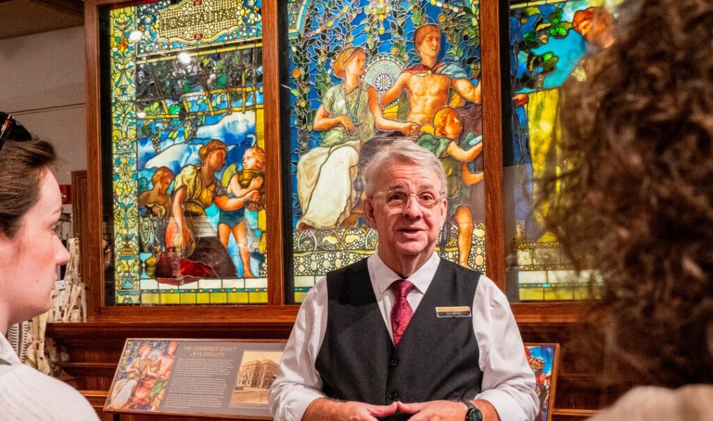 Biltmore Winery host in front of stained glass window display.