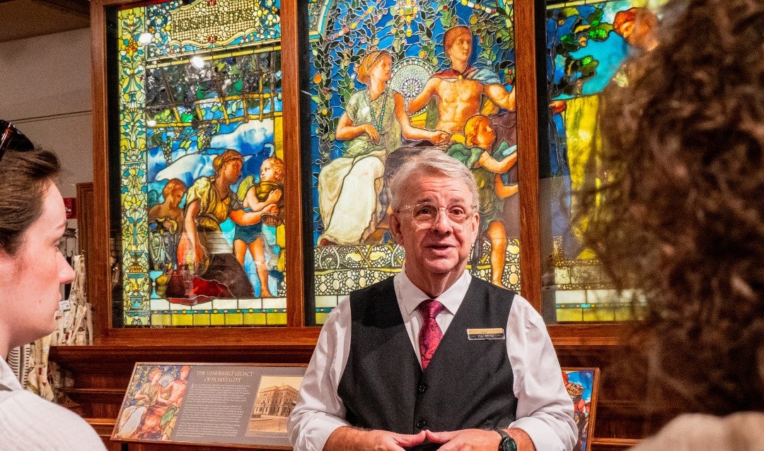 Biltmore Winery host in front of stained glass window display.