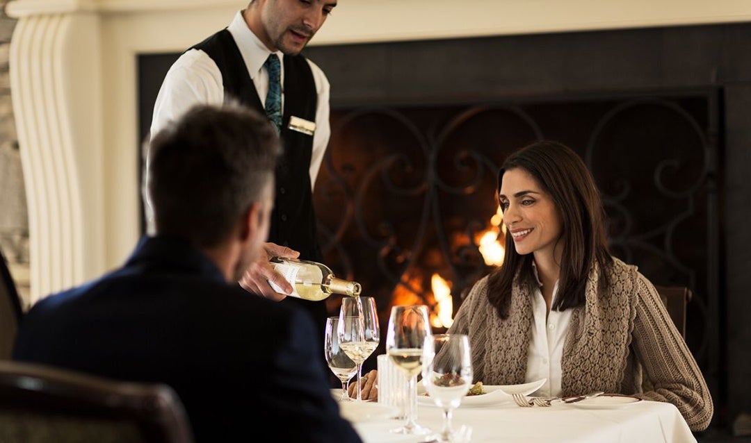 Couple dining by fireplace