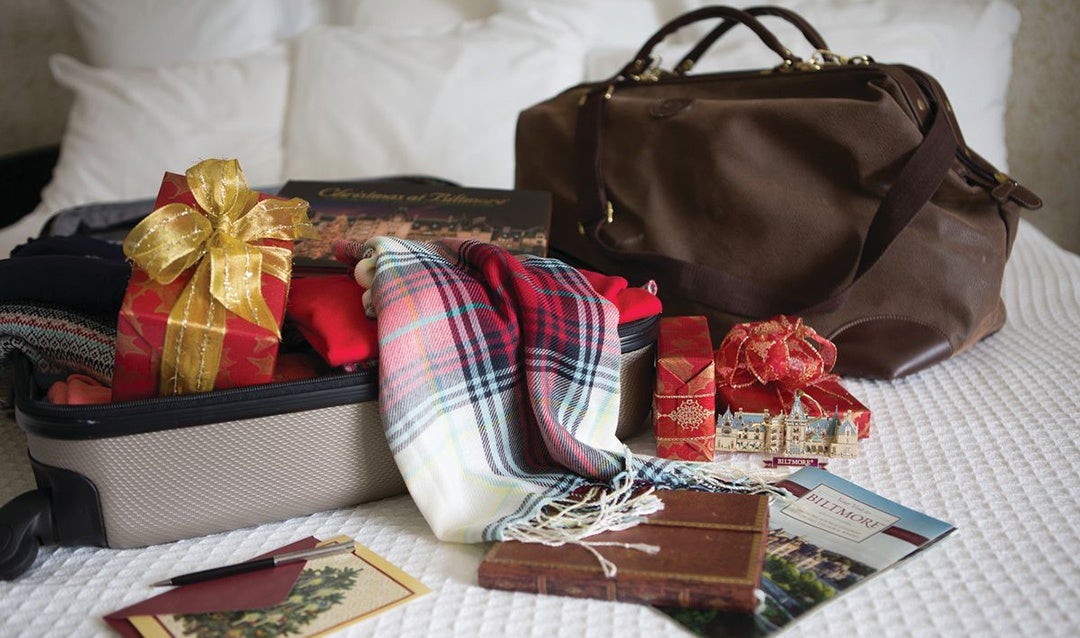 Luggage and christmas gift on bed