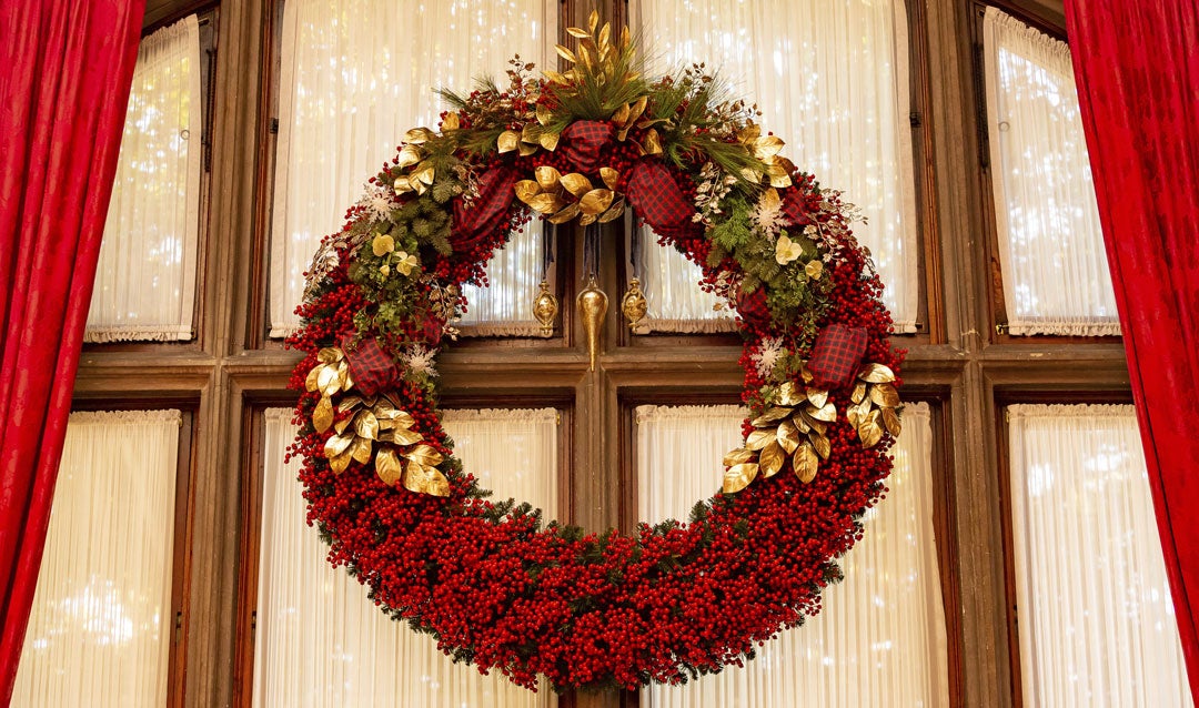 Enornous red berry wreath in the Library at Biltmore House