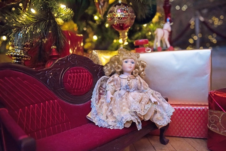 Vintage doll under the christmas tree in banquet hall.