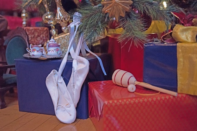 Ballet slippers ready for dance and play under the christmas tree in banquet hall.