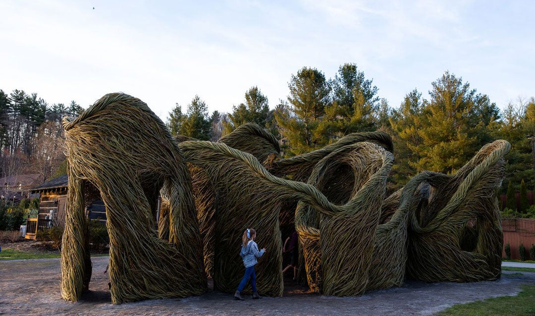 Child explores Stickwork sculpture in Antler Hill Village