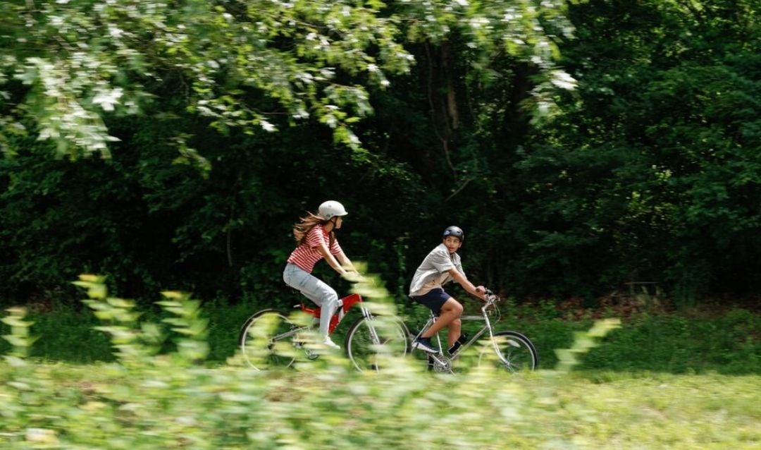 Two teens in helmets enjoy a bike ride at Biltmore.