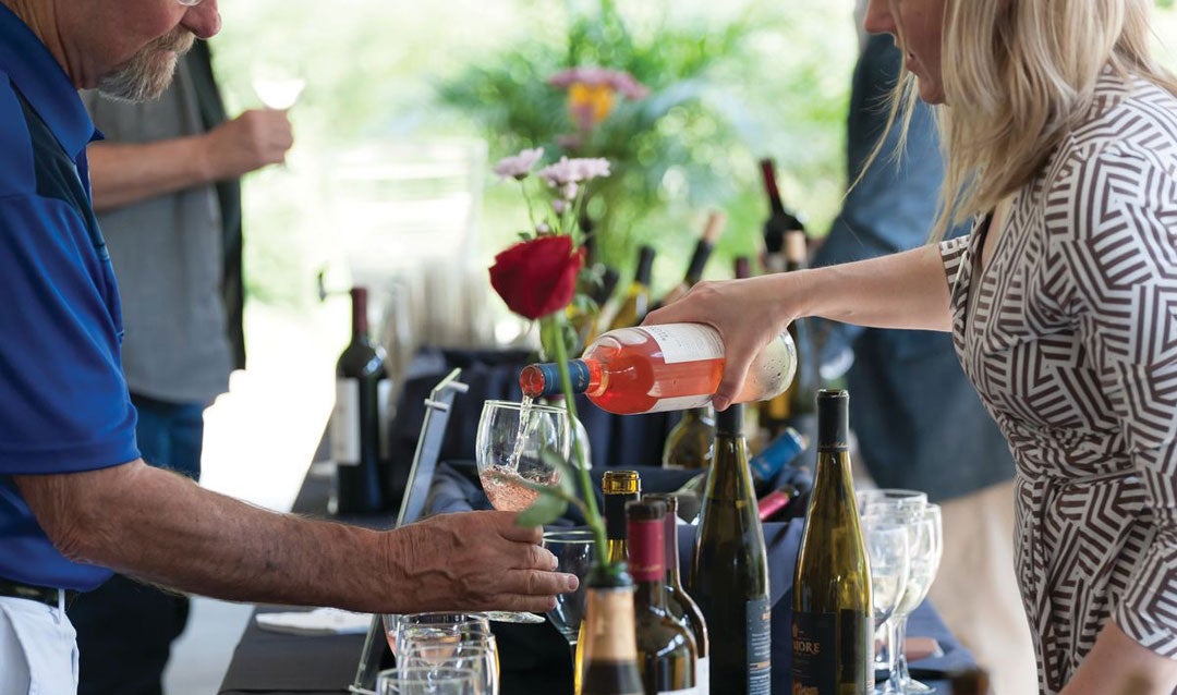 Woman pouring rosé wine into a glass