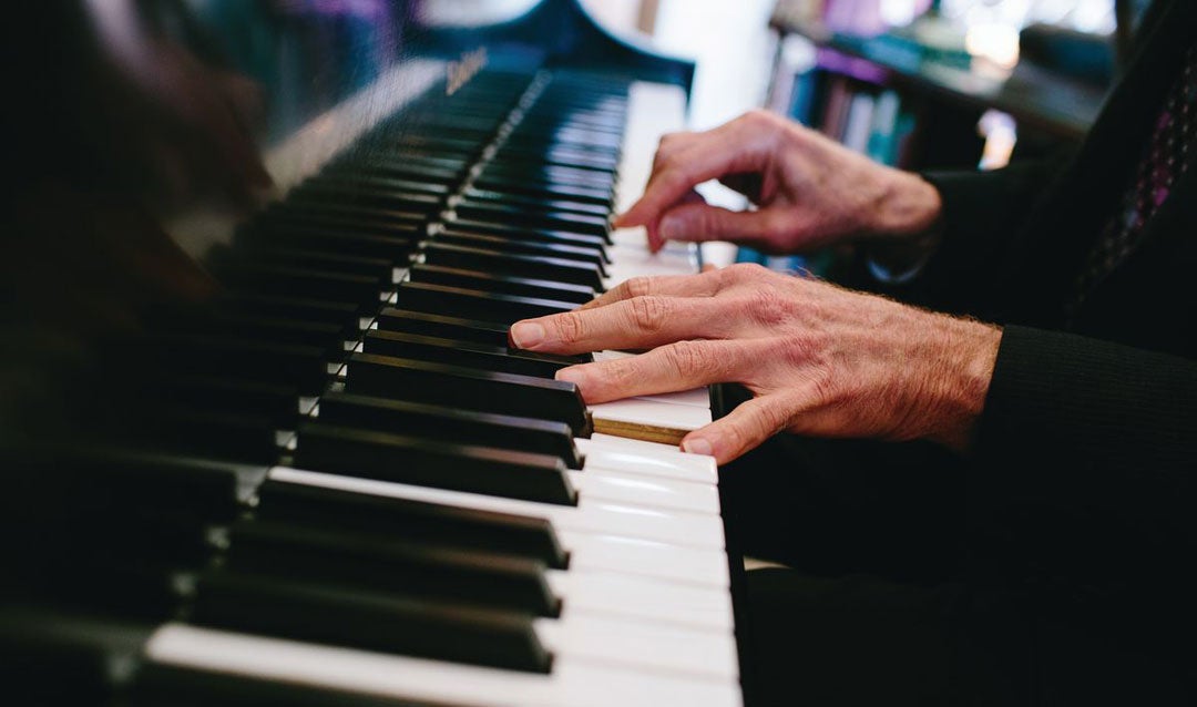 Hands playing a piano