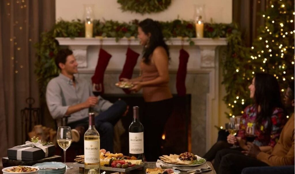 Couples gathered around a Christmas mantle with Biltmore wines in the foreground