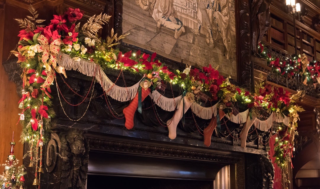Festive garland and stockings line the fireplace mantel in George Vanderbilt’s Library.