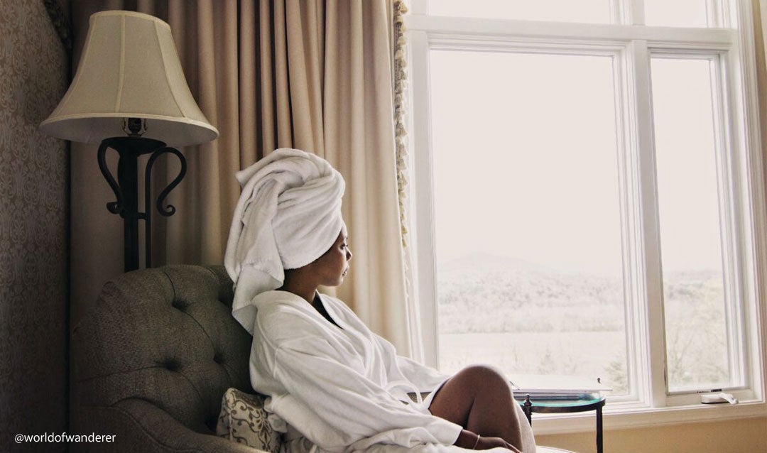 Woman with her hair in a towel by the window