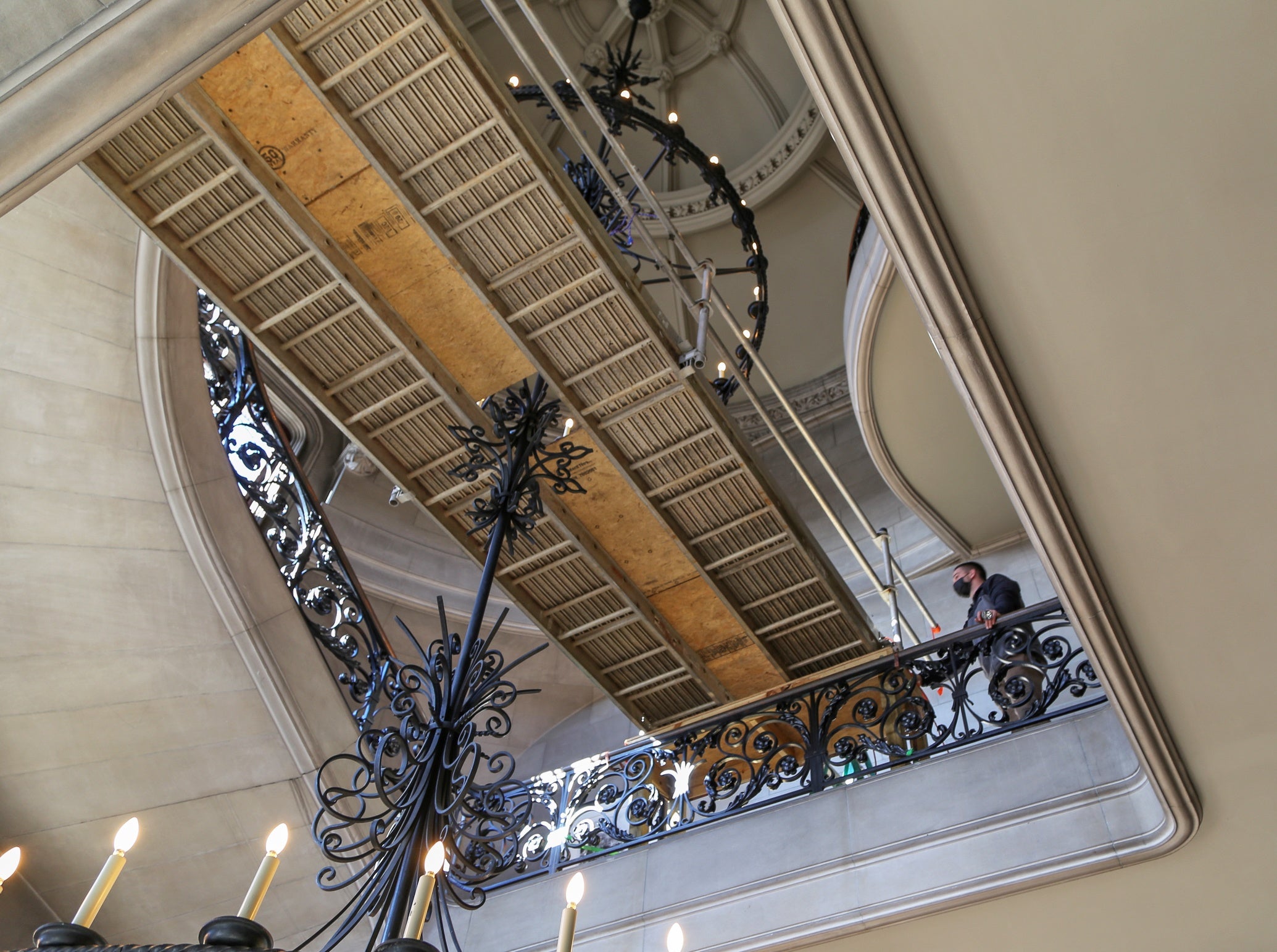 Below visual of Biltmore's housekeeping team cleaning the Grand Staircase chandelier