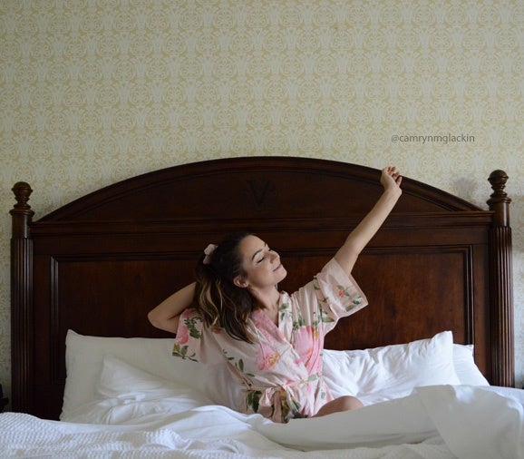 UGC image of @camrynmglackin doing a morning stretch in bed at The Inn on Biltmore Estate