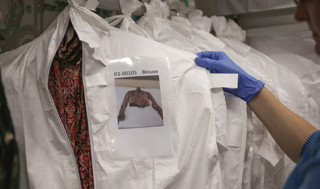 Clothing stored in dust bags on padded hangers in the Old Rose Room; photo by LeeAnn Donnelly