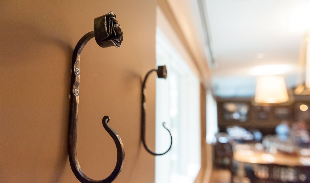 Our blacksmith’s early rose hooks are on display near the second floor fireplace in Village Hotel.