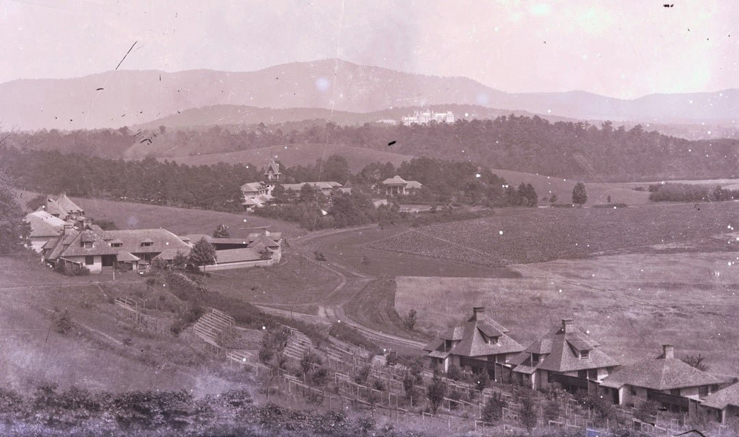 Archival image of the estate, c. 1906. The Line is in the foreground with the Barn to the left and the Main Dairy (what is now the Winery) in the center. Biltmore House is visible in the distance.
