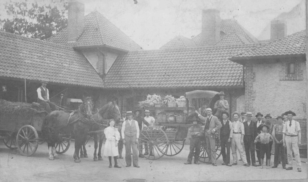 Archival photo of estate workers and residents with farm-to-table foods at the Market Gardener's Cottage at Biltmore.