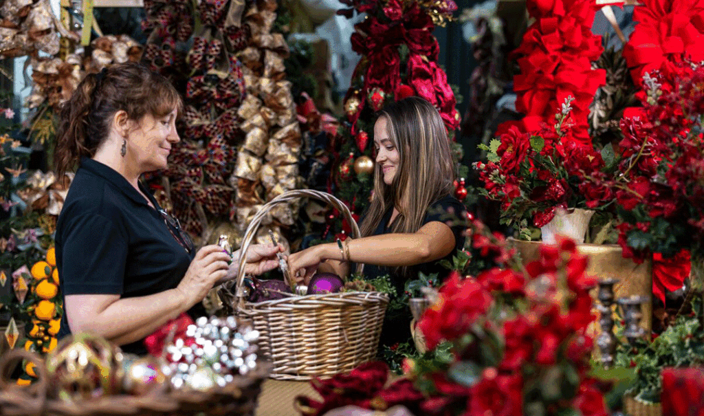 Two women place ornaments in a basket