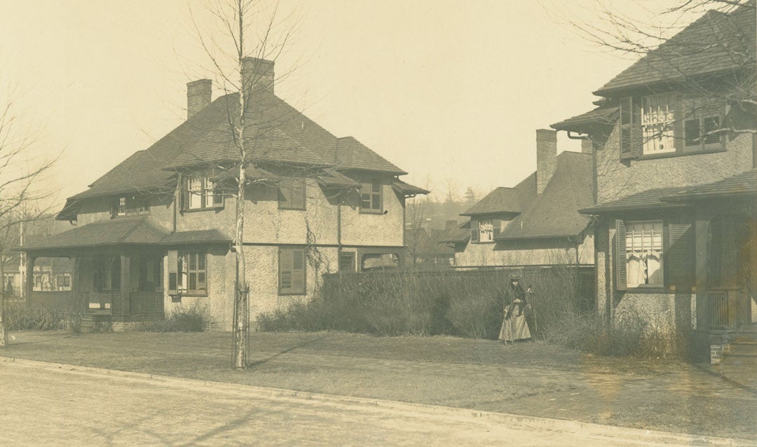 Archival photograph of Edith Vanderbilt with a camera and tripod in Biltmore Village during photography excursion