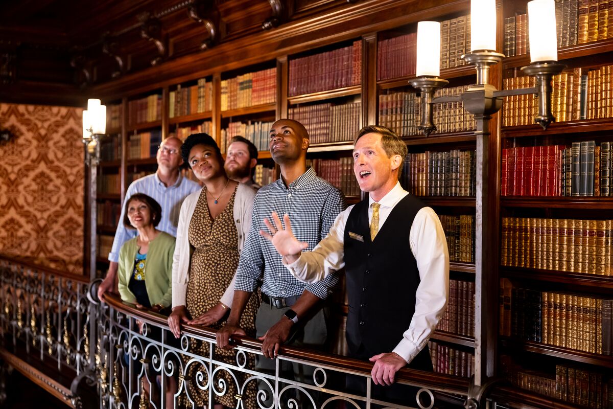 Biltmore host guides a small group tour in the Library.