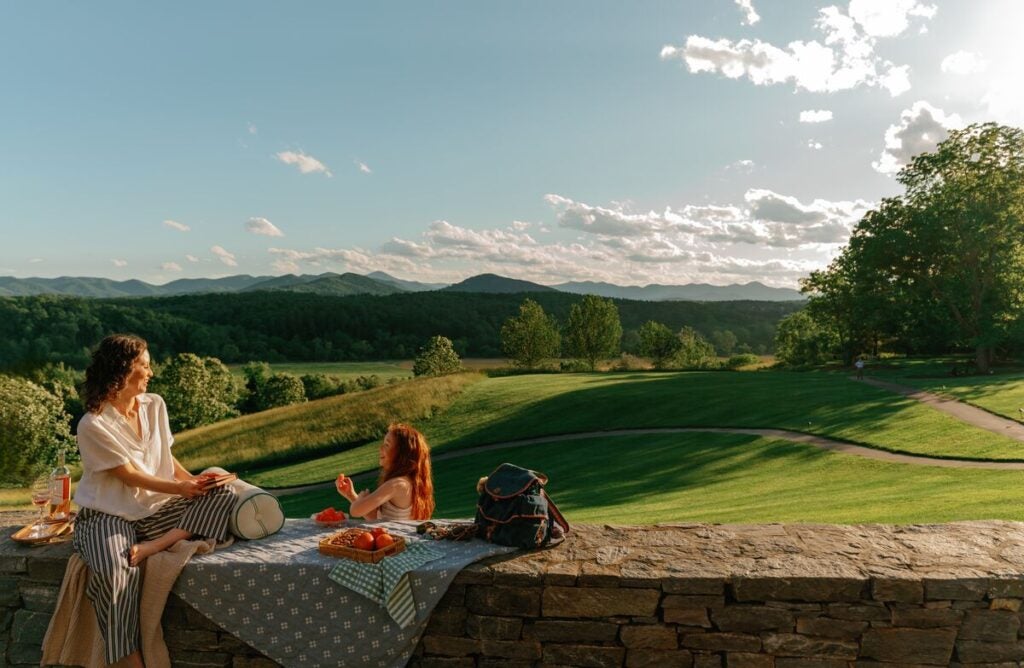 Mother and daughter enjoying a picnic on the wall below The Inn on Biltmore Estate.