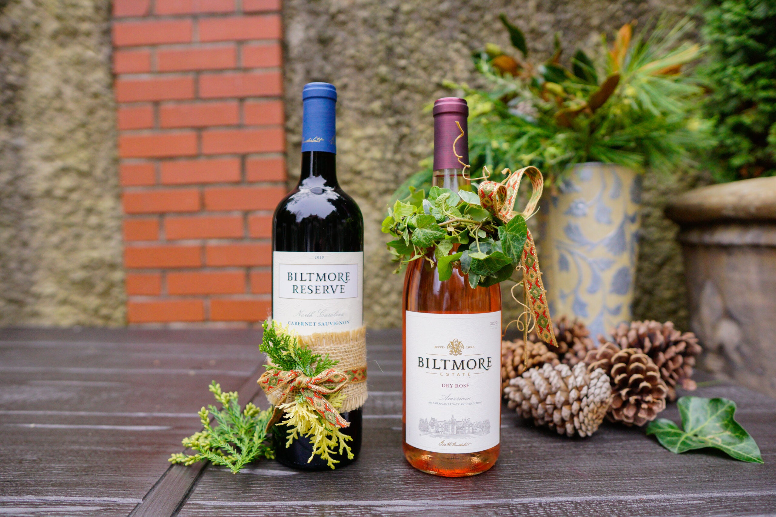 Simple evergreen clippings and leftover ribbon pieces can help elevate your wine gift-giving this holiday season.