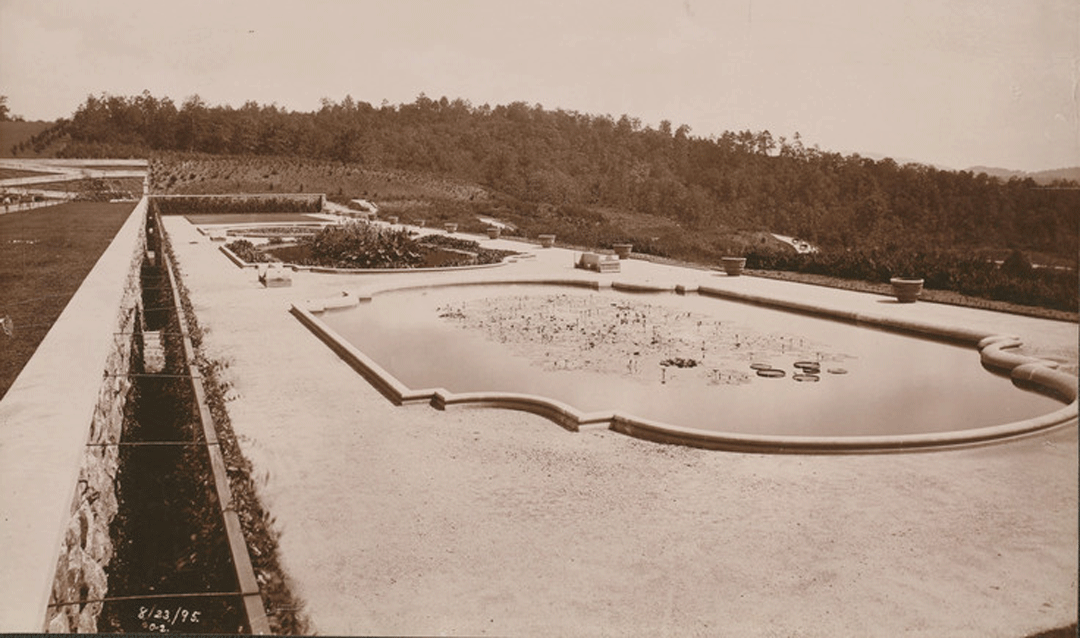 Archival Biltmore photo of a pond in a garden with planters beside it