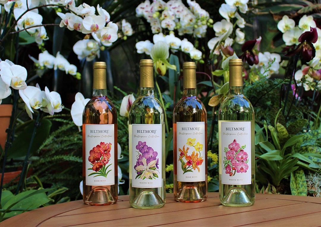 Four bottles of Biltmore Masterpiece Collection White and Rosé Wines with glasses and fruit.