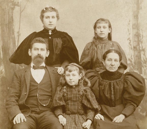 Karl Maschker (a white man) poses for a portrait with his wife, Clara, and his daughters, Selma, Elsie, and Lizzie.