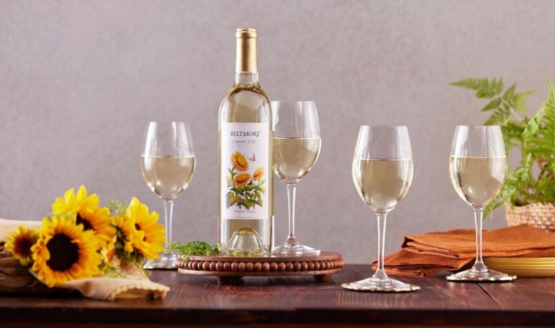 Bottle of Biltmore Masterpiece Collection White Wine with sunflowers and glasses.