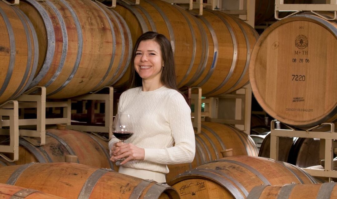 Biltmore winemaker Sharon Fenchak in the Barrel Room with a glass of red wine.