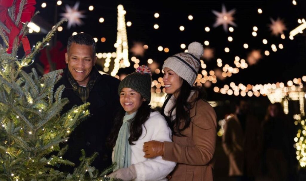 Family of three enjoying the illumination of Antler Hill Village at Biltmore.