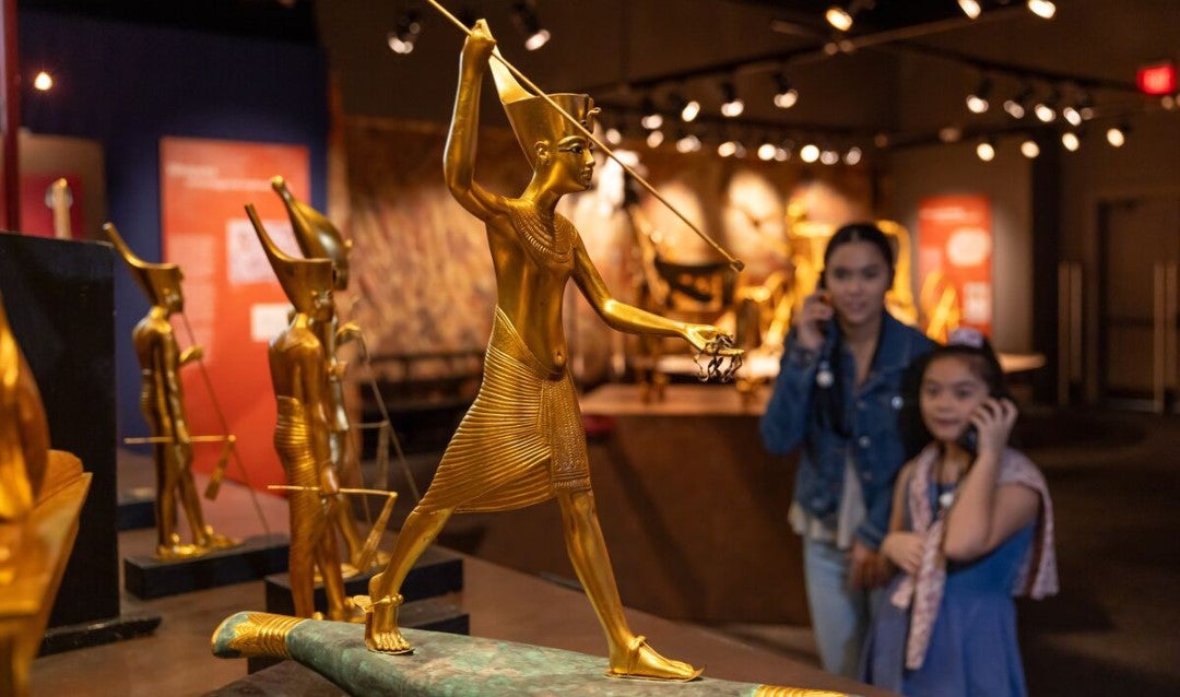 Two girls listening to an audio guide describing the treasures of King Tut's tomb at Biltmore.
