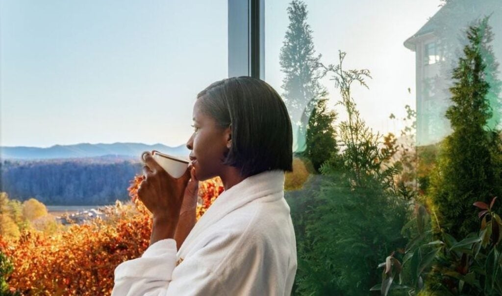 Woman wearing a bathrobe and drinking a cup of coffee at The Inn on Biltmore Estate