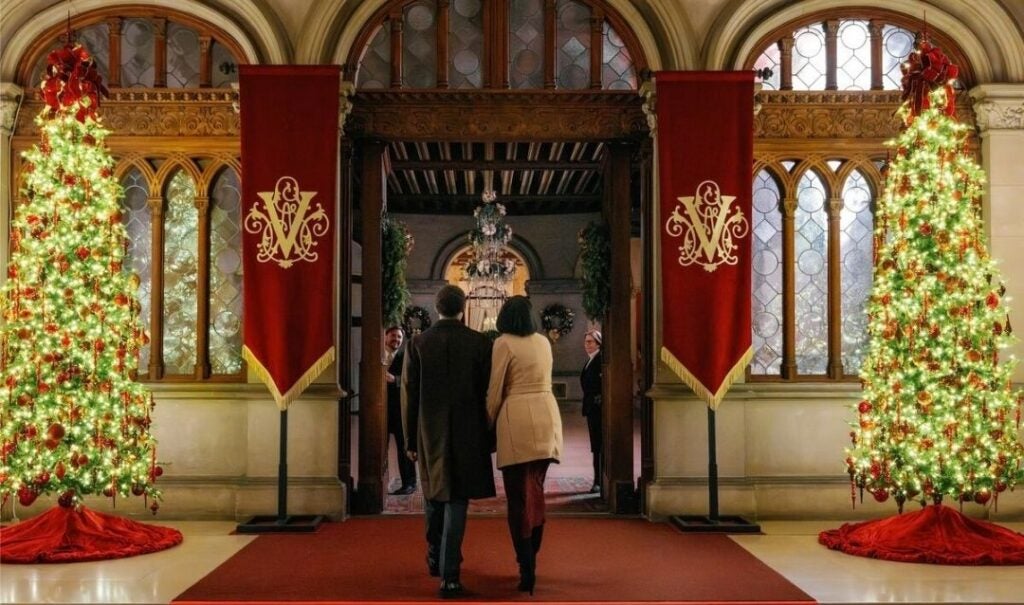 Couple walks into the Vestibule of Biltmore House decorated for Christmas