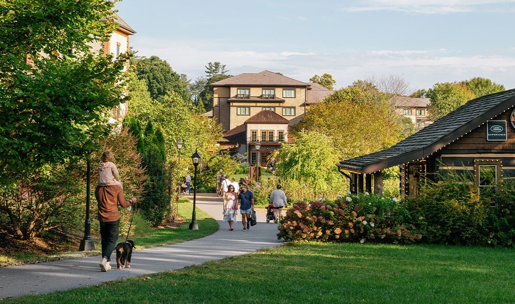 Antler Hill Village cast in warm sunshine with people walking along paved paths