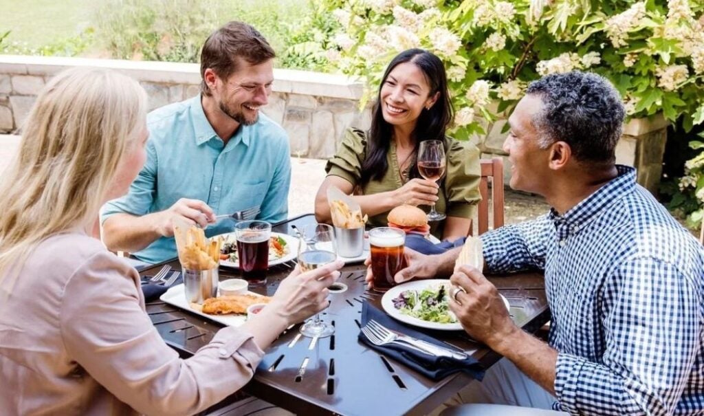 Two couples enjoying outdoor dining at Cedric's Tavern in Antler Hill Village at Biltmore.