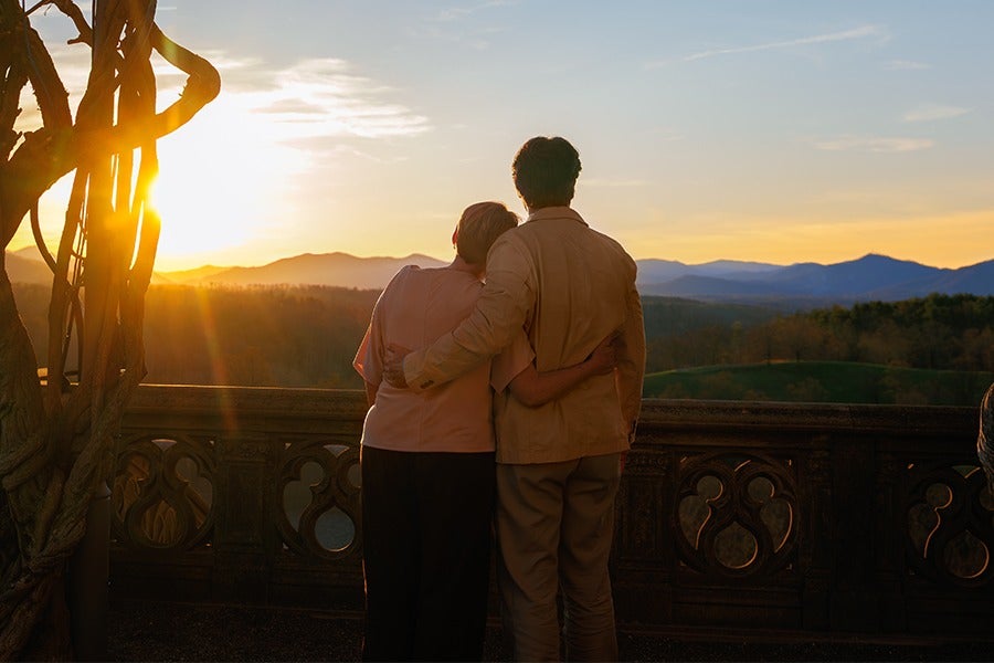 Couple shares silhouetted embrace while watching the sunset from Biltmore's Library Terrace