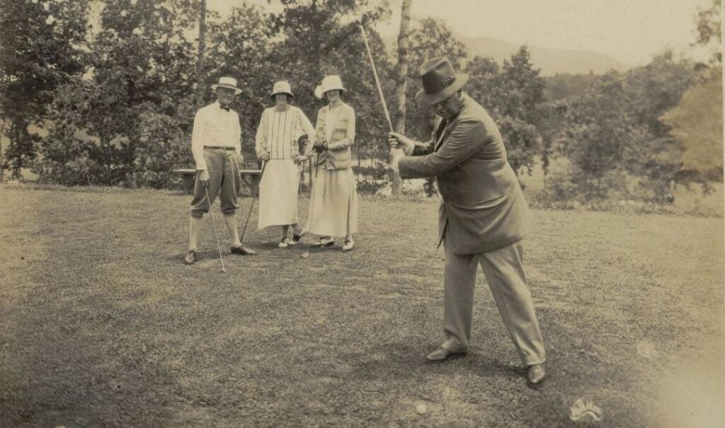 Archival photo of Don Juan Riaño y Gayangos, first Spanish Ambassador to the US, playing golf while Judge Junius Adams, Cornelia Vanderbilt, and Edith Vanderbilt watch in the background. (Photo by Herbert W. Pelton on July 4, 1923, to celebrate the 1st anniversary of Biltmore Forest Country Club.)