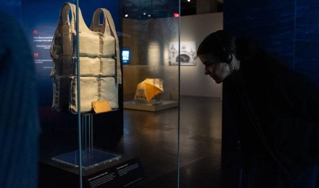 Guest looks at a life vest from RMS Titanic on display in an exhibition
