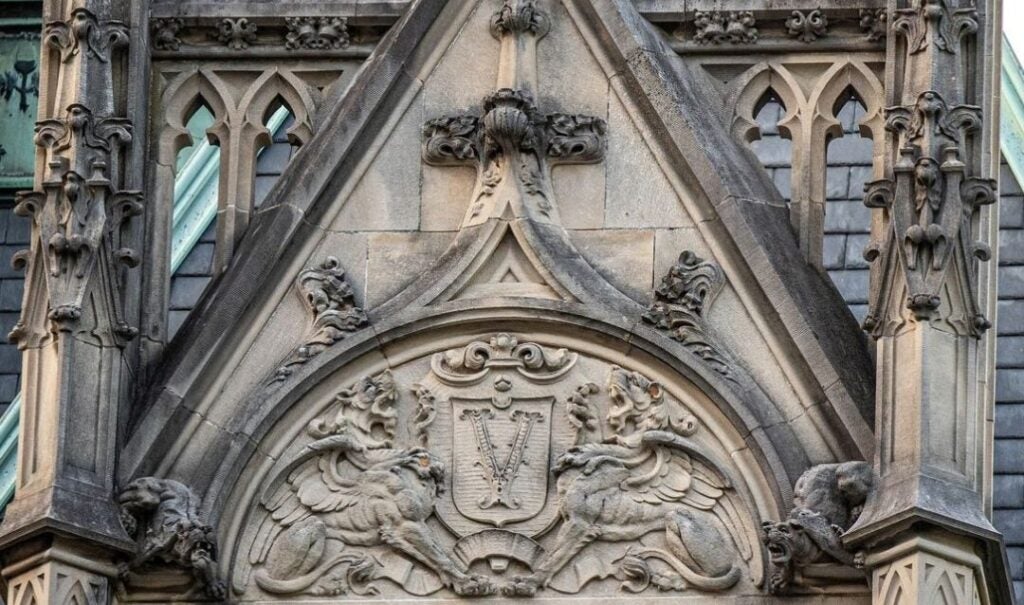 Two winged griffon-style creatures hold a crest or shield with the Vanderbilt 