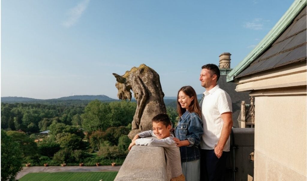 A family standing next to a grotesque on a guided Rooftop Tour of Biltmore House